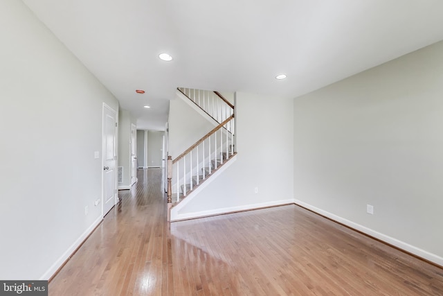 spare room with stairway, baseboards, recessed lighting, and wood finished floors
