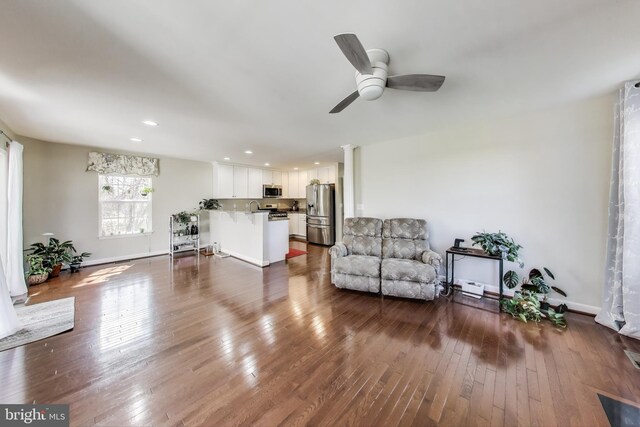 living room with a ceiling fan, dark wood finished floors, recessed lighting, baseboards, and decorative columns