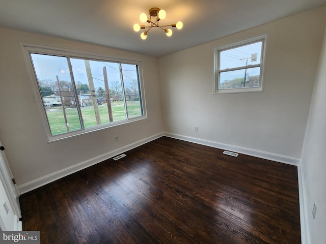 1261 Gallatin St NE, Washington, DC 20017 - empty room featuring baseboards, dark wood-style flooring, visible vents, and an inviting chandelier