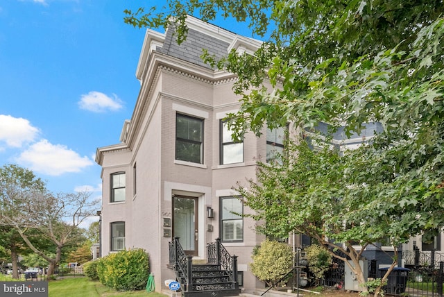 900 11th St NE Unit 1, Washington, DC 20002 - view of front facade featuring brick siding, fence, and mansard roof