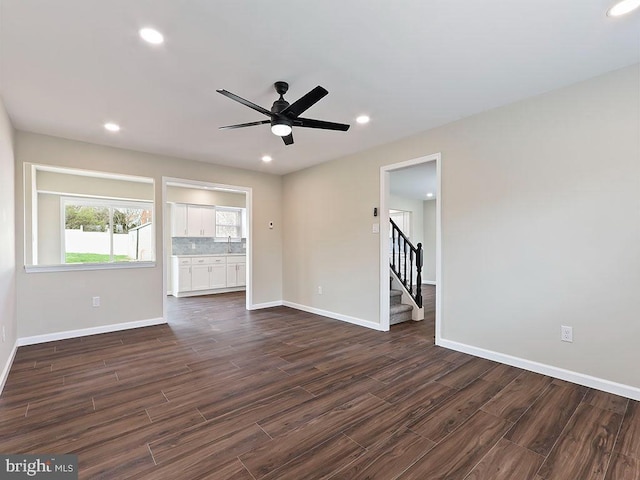 unfurnished living room featuring baseboards, recessed lighting, stairway, dark wood-style floors, and ceiling fan
