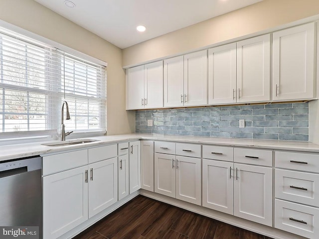 kitchen featuring white cabinetry, dishwasher, a sink, dark wood-style flooring, and backsplash