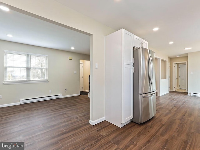kitchen featuring dark wood-type flooring, a baseboard radiator, freestanding refrigerator, and white cabinets
