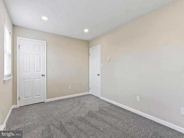 carpeted empty room featuring recessed lighting and baseboards