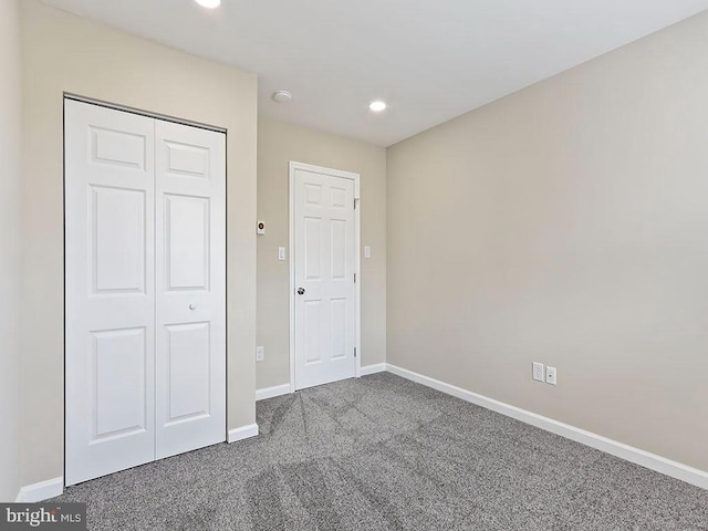 unfurnished bedroom with a closet, recessed lighting, baseboards, and carpet floors