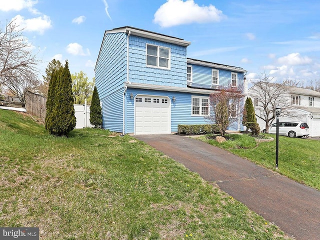 view of front of house with a garage, aphalt driveway, fence, and a front yard