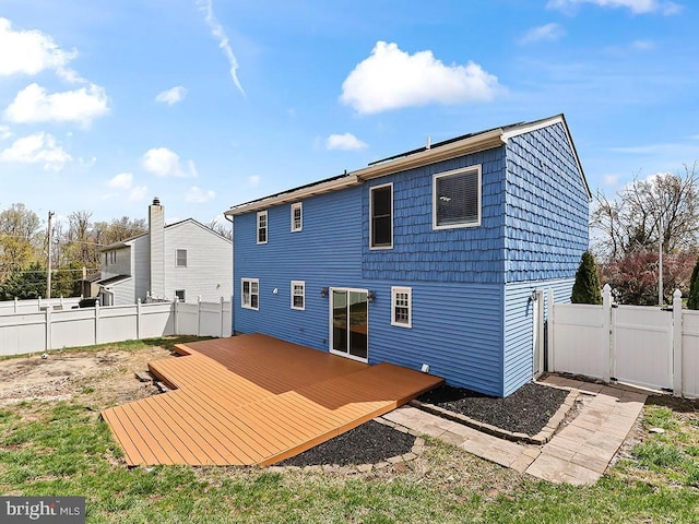 rear view of house featuring a deck, a gate, and fence private yard