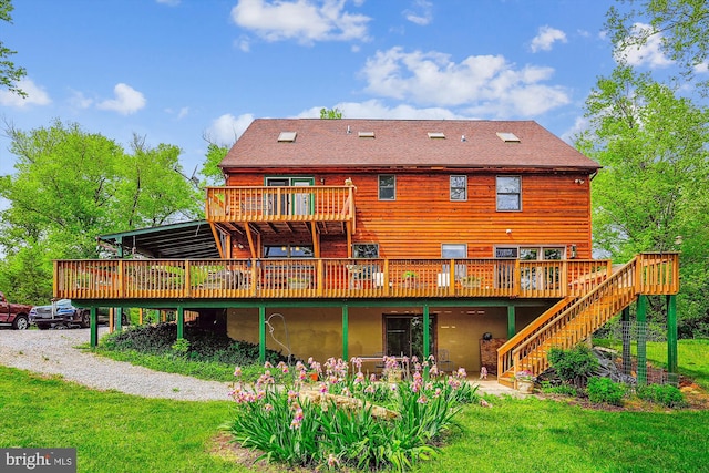 rear view of house featuring stairway, a deck, and a lawn
