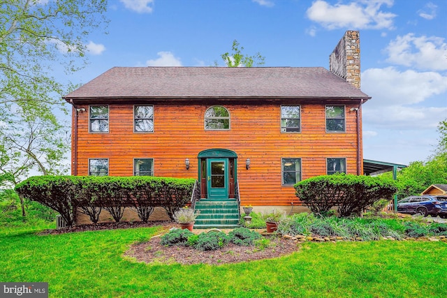view of front of property featuring a front lawn and a chimney