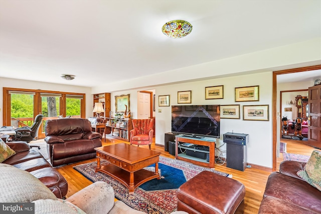 living area with baseboards and wood finished floors