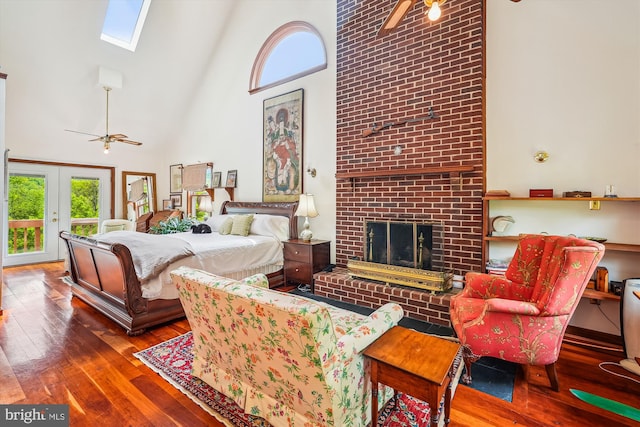 bedroom with multiple windows, a brick fireplace, hardwood / wood-style floors, and high vaulted ceiling