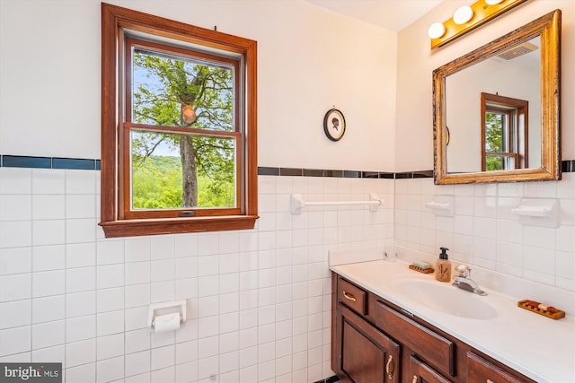 bathroom featuring wainscoting, vanity, and tile walls