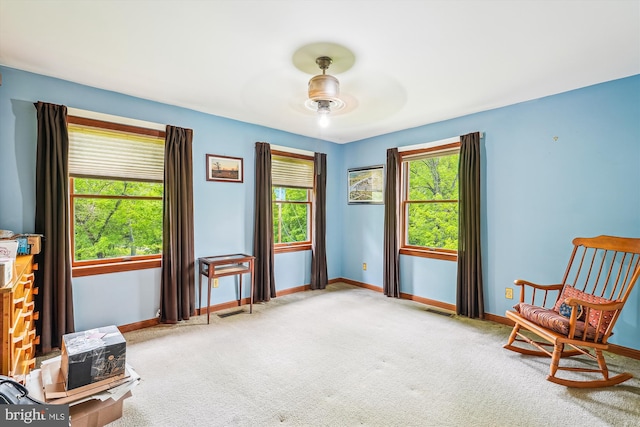 sitting room featuring baseboards, ceiling fan, and carpet