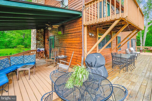 wooden terrace featuring ceiling fan and outdoor dining space