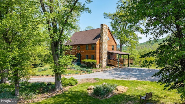 view of front of home with a chimney, a front yard, and stairway