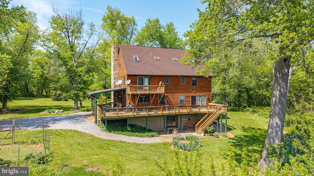 rear view of house with a chimney, a yard, driveway, stairs, and a deck