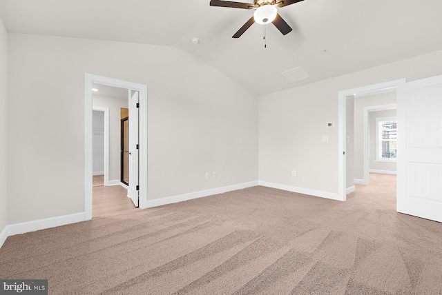 spare room featuring baseboards, carpet floors, ceiling fan, and vaulted ceiling