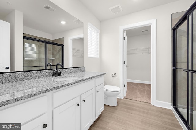 full bath featuring visible vents, a stall shower, toilet, and vanity