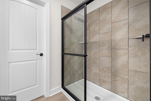 full bathroom featuring a stall shower and wood finished floors
