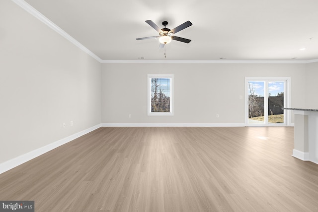 unfurnished living room with baseboards, ornamental molding, a ceiling fan, and light wood finished floors