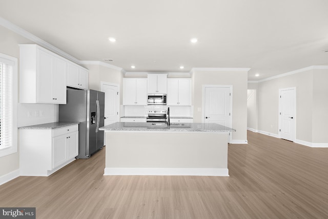 kitchen with white cabinetry, a kitchen island with sink, light wood finished floors, and appliances with stainless steel finishes
