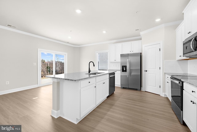 kitchen featuring tasteful backsplash, light wood-type flooring, a sink, visible vents, and appliances with stainless steel finishes