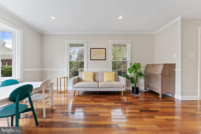 living area with wood finished floors, ornamental molding, baseboards, and recessed lighting
