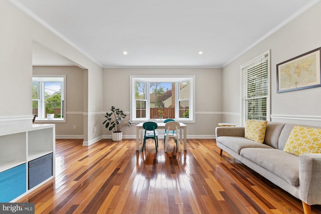 living room featuring hardwood / wood-style flooring, crown molding, baseboards, and recessed lighting