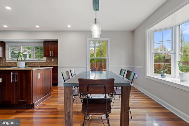 dining area featuring light wood-style flooring, baseboards, and recessed lighting