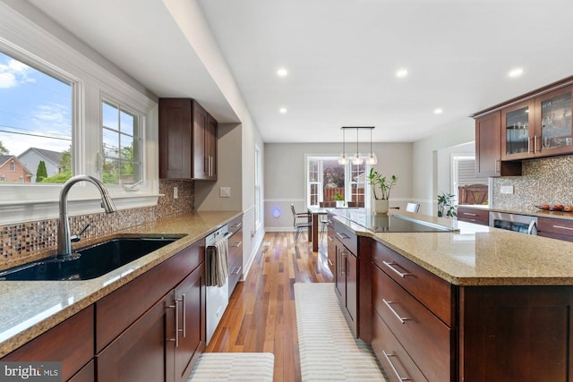 kitchen with a sink, tasteful backsplash, recessed lighting, plenty of natural light, and light wood-style flooring
