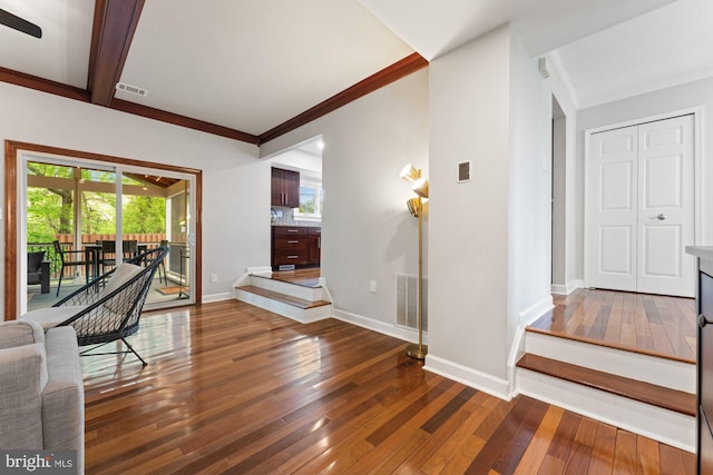 foyer entrance with hardwood / wood-style floors, plenty of natural light, ornamental molding, and baseboards