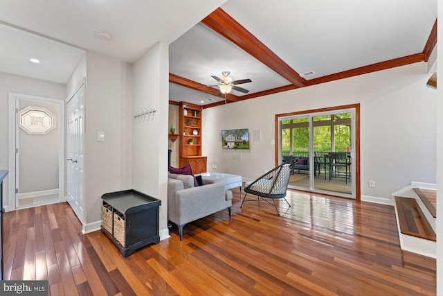 living area featuring baseboards, wood finished floors, a ceiling fan, beamed ceiling, and recessed lighting