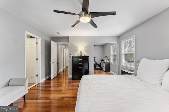 bedroom with dark wood-style flooring, baseboards, and a ceiling fan