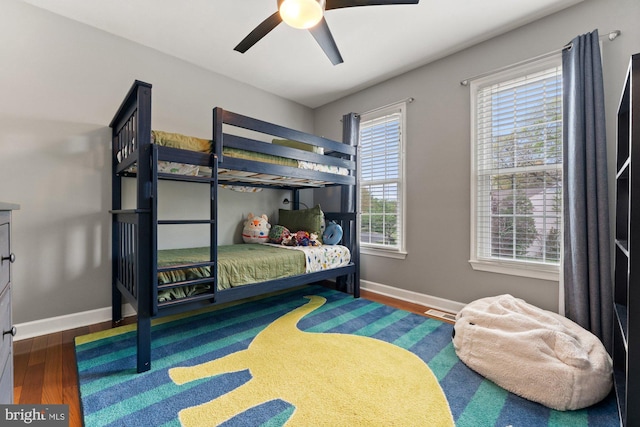 bedroom featuring wood finished floors, baseboards, and a ceiling fan