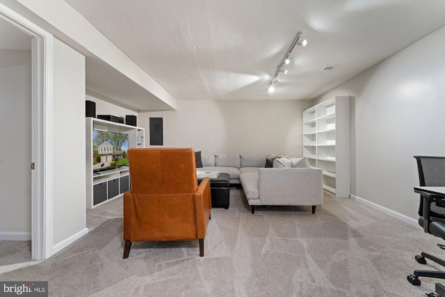 living room featuring carpet flooring, track lighting, and baseboards