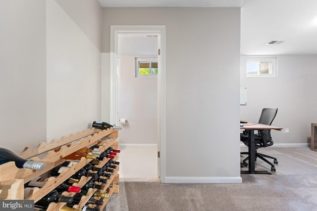 wine area featuring carpet, plenty of natural light, and baseboards