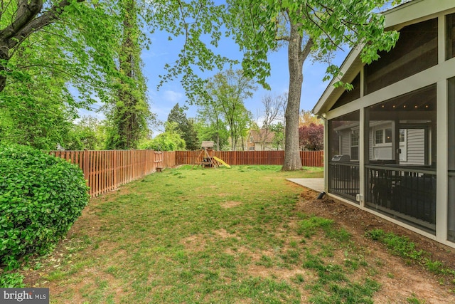 view of yard featuring a playground and a sunroom