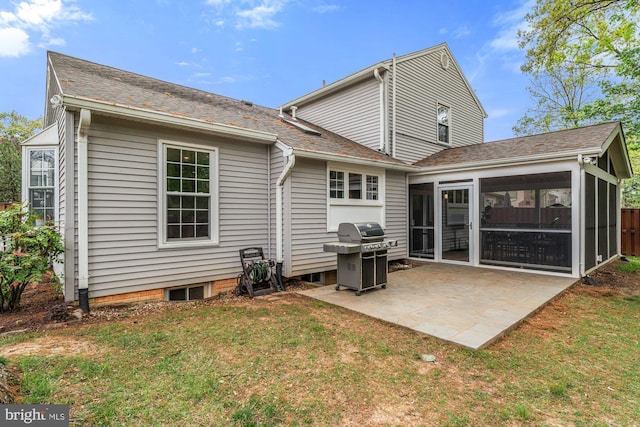 back of house with a sunroom, a patio area, a lawn, and a shingled roof