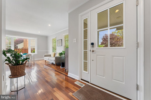 entryway featuring wood-type flooring, ornamental molding, baseboards, and recessed lighting