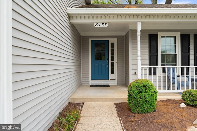 view of exterior entry with a porch