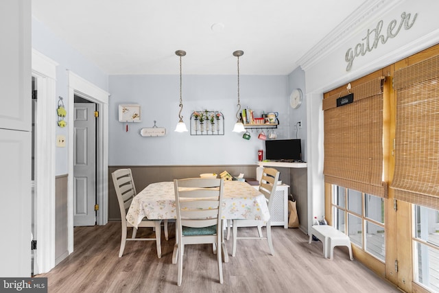 dining room with a wainscoted wall and wood finished floors