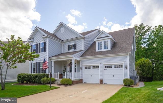 187 Verbena Dr, Stafford, VA 22554 - traditional-style house featuring a porch, driveway, a front lawn, an attached garage, and roof with shingles