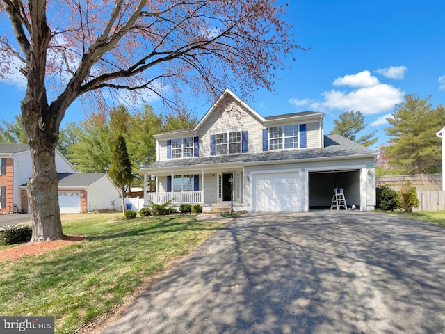 view of front facade with driveway, a front yard, covered porch, fence, and an attached garage
