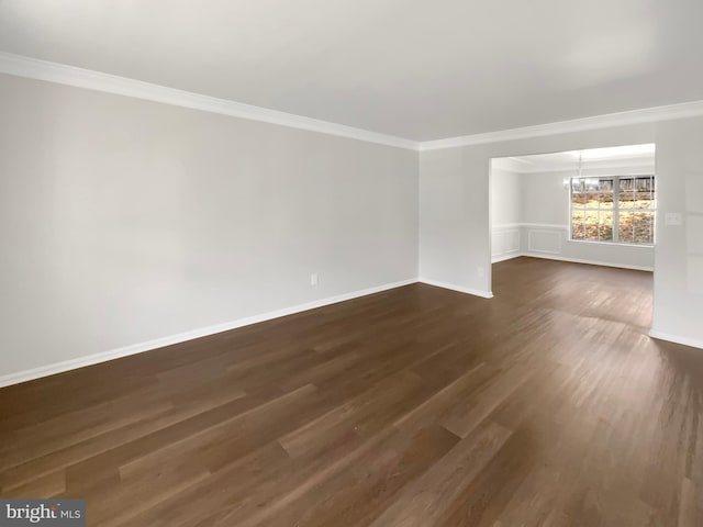 unfurnished room with dark wood finished floors, baseboards, crown molding, and a chandelier
