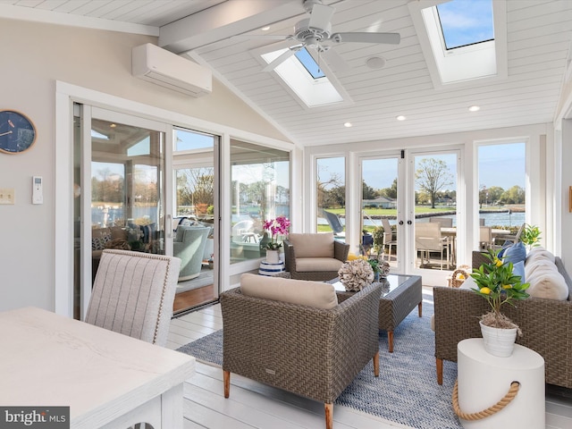 sunroom / solarium with an AC wall unit, a wealth of natural light, a ceiling fan, and lofted ceiling with skylight