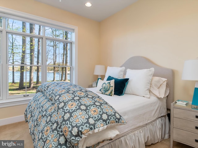 carpeted bedroom featuring a water view, baseboards, and recessed lighting