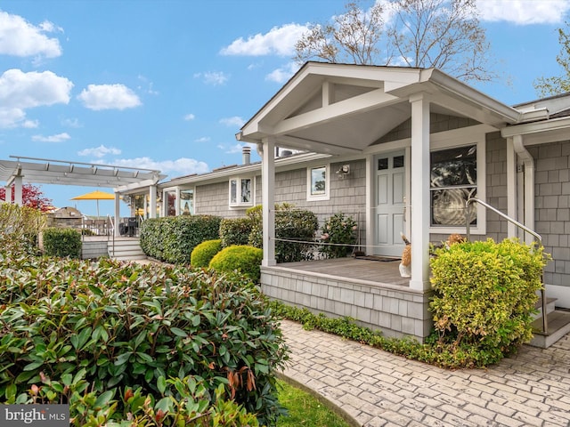 entrance to property with a pergola