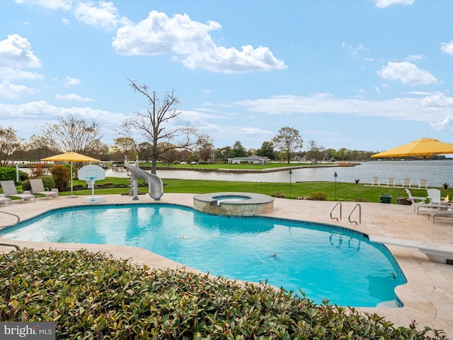 outdoor pool with a diving board, a water slide, a water view, a patio, and an in ground hot tub