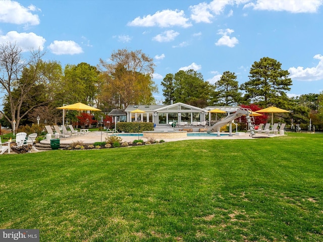 view of property's community featuring a yard, a patio area, and a pool