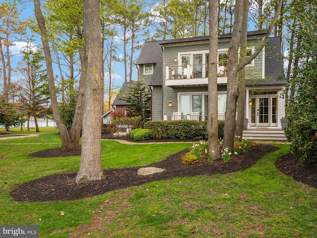 view of front of home with a balcony and a front lawn